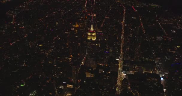 帝国大厦顶部明亮的部分和尖顶。倾斜揭示了夜景.美国，纽约市，曼哈顿 — 图库视频影像