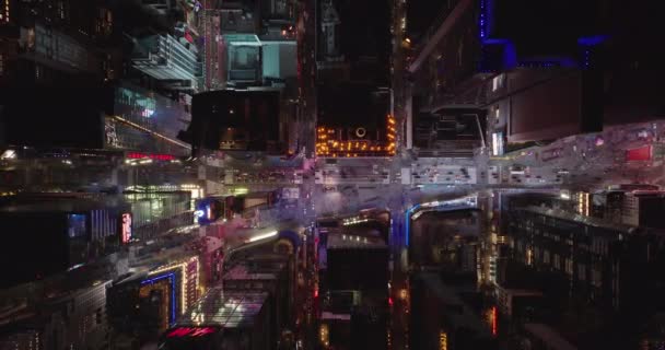 Mata burung udara di atas kepala ke bawah menaik pemandangan yang sangat bercahaya Times Square. Mobil mengemudi di jalan antara bangunan tinggi di kota malam hari. Manhattan, New York City, Amerika Serikat — Stok Video