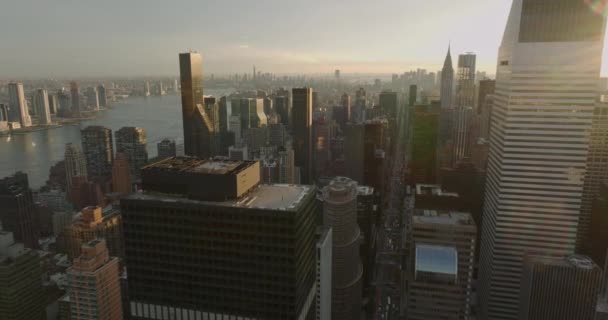 Aerial panoramic footage of buildings in city at sunset time. Wide rive in background. Manhattan, New York City, USA — Stockvideo