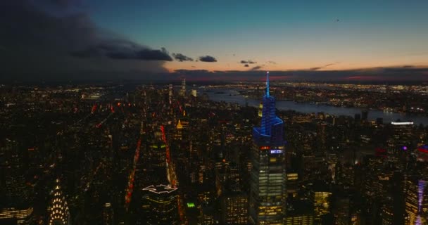 Za soumraku letíme nad centrem města. Úžasný letecký pohled na večerní městskou krajinu s osvětlenými mrakodrapy. Manhattan, New York City, USA — Stock video
