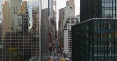 Forwardlar caddenin üzerinde uçar. Yol, yüksek ofis ya da apartman binalarıyla dolu. Parlak cam cephe çevreyi yansıtıyor. Manhattan, New York City, ABD