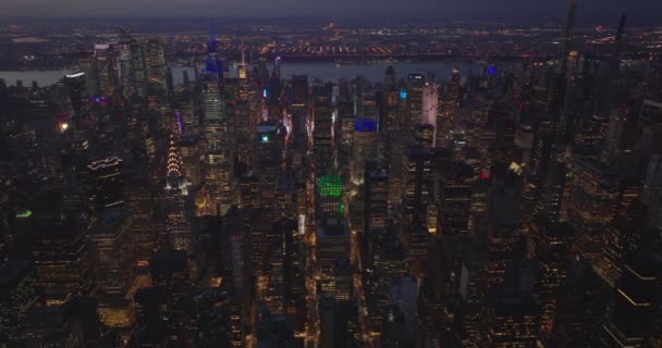 Aerial evening footage of rows of skyscrapers along streets in midtown. Cityscape after sunset. Manhattan, New York City, USA — Video Stock