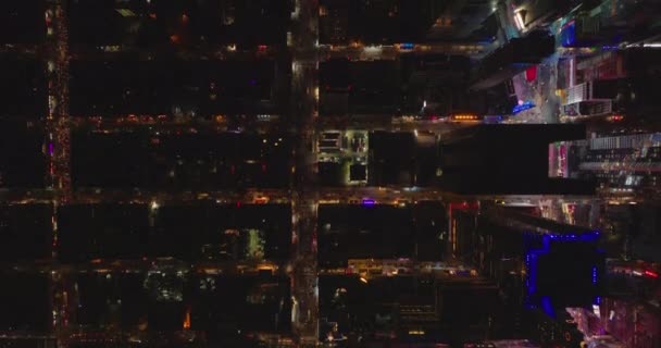 Luchtvogels oog boven hoofd naar beneden panning uitzicht op stress en gebouwen in de nacht stad. Donkere straten contrasteren met het gebied rond Times Square. Manhattan, New York City, Verenigde Staten — Stockvideo