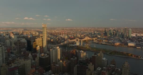 Vue panoramique aérienne du pont Queensboro sur l'île d'East River. Paysage urbain éclairé par le soleil couchant. Manhattan, New York, États-Unis — Video