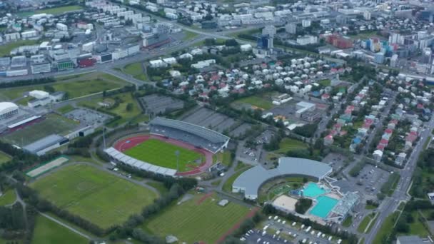Birds eye view of sport complex in Reykjavik suburbs, Iceland, with swimming pool and football fields. Aerial view of Laugardalsvollur football arena, the home of the Icelandic national team — 图库视频影像