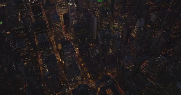 Gece şehrinin yüksek açılı manzarası. Yüksek binaları olan şehir manzarasını yukarı doğru eğ. Manhattan, New York City, ABD — Stok video