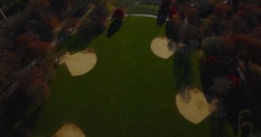 The Great Lawn 'daki beyzbol sahaları Central Park' taki renkli sonbahar ağaçları arasında. Yukarı kaldır ve modern şehir merkezindeki gökdelenleri ortaya çıkar. Manhattan, New York City, ABD