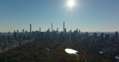 Central Park ve şehir merkezindeki gökdelenlerin panoramik görüntüleri güneşe karşı. Arka planda sonbahar manzarası. Manhattan, New York City, ABD