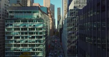 Şehir merkezine doğru uzun düz bir caddenin üzerinden uç. Birçok penceresi olan çeşitli ofis ya da ticari binalar. Manhattan, New York City, ABD