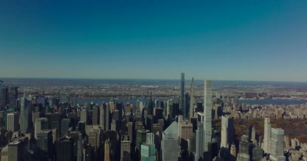 Panoramic slider of midtown skyscrapers and autumn colour trees in Central Park. Clear sky on sunny day. Manhattan, New York City, USA — Stock Video