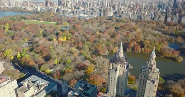 Fly over San Remo building. Large house with two tall towers against autumn colour trees in Central Park. Manhattan, New York City, USA — стоковое видео