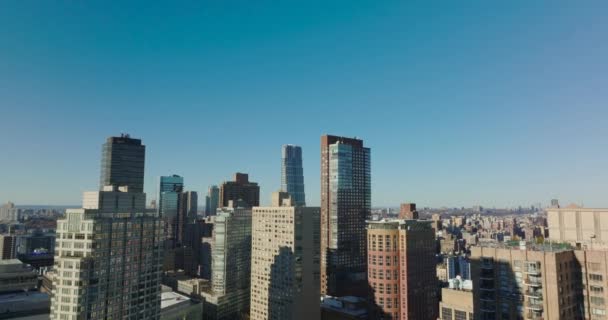 前进在城市上空飞行.阳光灿烂的日子里,蓝色的天空映衬着高大的公寓楼.美国，纽约市，曼哈顿 — 图库视频影像