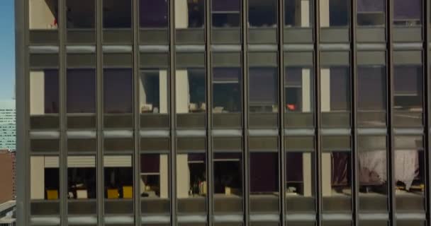 Pencereli tuğla duvarın yükselen görüntüsü. Yüksek binalar boyunca uçun. Şehir manzarasını gözler önüne seriyor. Manhattan, New York City, ABD — Stok video