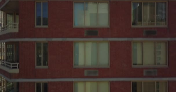 Pencereli kırmızı tuğla duvar boyunca yükseliyor. Nehir kıyısındaki modern apartman binalarının manzarası. Manhattan, New York City, ABD — Stok video