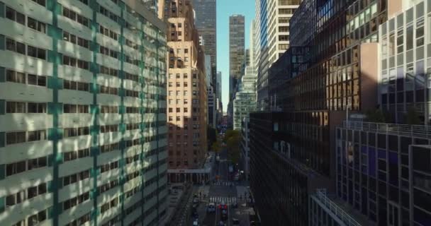 Maju terbang di atas jalan antara gedung-gedung tinggi modern dengan fasad warna. Manhattan, New York City, Amerika Serikat — Stok Video