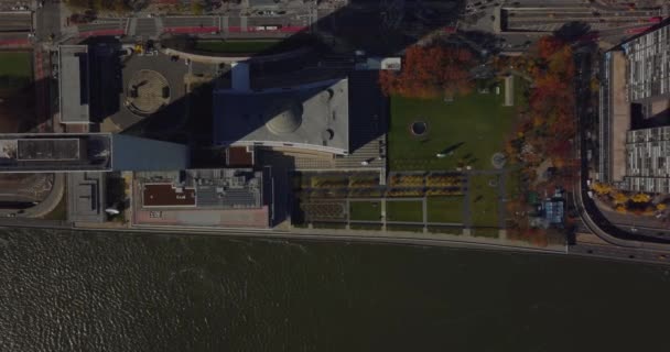 Aerial birds eye overhead top down view of UN headquarters buildings on East River waterfront. Autumn colour trees and busy road. Manhattan, New York City, USA — стоковое видео