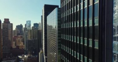 Yüksek binaların parlak duvarı boyunca yükselen görüntüler. Gökdelenlerle şehir manzarasını gözler önüne sermek. Manhattan, New York City, ABD