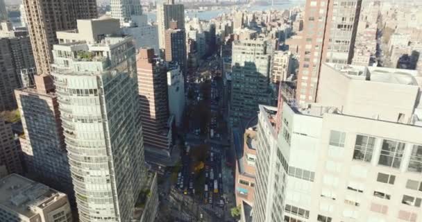 Forwards descending fly above wide street clogged with heavy traffic. High rise buildings in city. Manhattan, New York City, USA — стокове відео