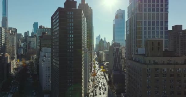 Adelante volar por encima del cruce de la calle y entre edificios modernos de gran altura en la ciudad en el día soleado. Manhattan, Nueva York, Estados Unidos — Vídeo de stock