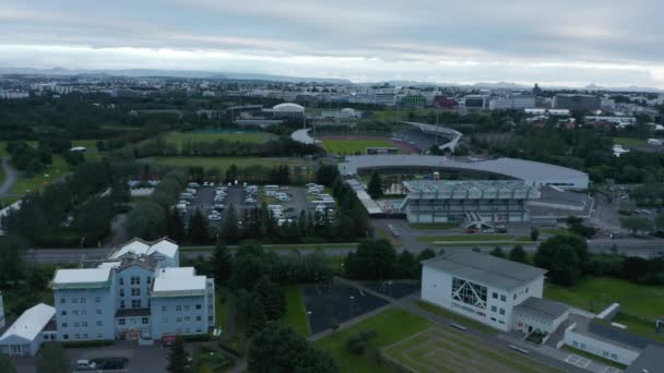 Letecký pohled na fotbalovou arénu Laugardalsvollur, domov islandského národního fotbalového týmu. Pohled z ptačí perspektivy na sportovní areál na předměstí Reykjavíku, Island, s bazénem a fotbalovými hřišti — Stock video