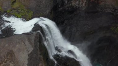 Derinlere düşen beyaz suyun yüksek açılı görüntüsü. Uzun bir şelale. Nefes al, derin derin bilgi al. Haifoss, İzlanda
