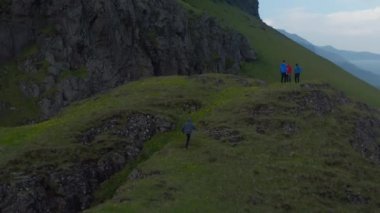 Bir grup genç, kırsalda fotoğraf çekerek ve nefes alıp vererek İskandinav manzarası çekerek vakit geçiriyor. İzlanda