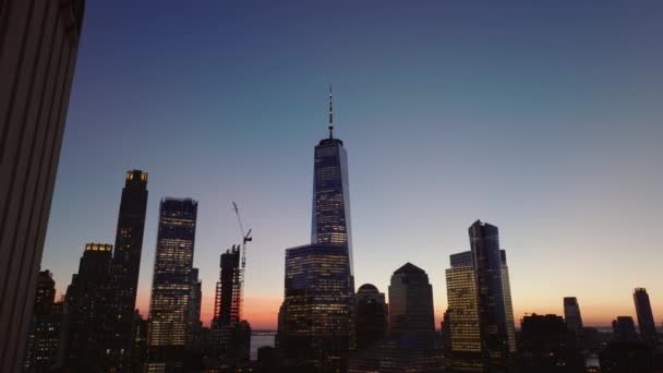 市中心摩天大楼的轮廓映衬着五彩斑斓的暮色天空.向后揭示了城里的高层建筑.美国，纽约市，曼哈顿 — 图库视频影像