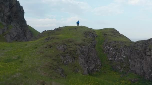 한 쌍의 사람들이 높은 자세로 서서 드론을 조종하고 있습니다. 푸른 광막 한 계곡 과산을 배경으로 하는 전경 이 한눈에 들어옵니다. 아이슬란드 — 비디오