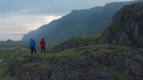 Orbit shot around group of people taking photos of preserved Nordic landscape in morning. Standing on elevated place. Iceland — Stock Video