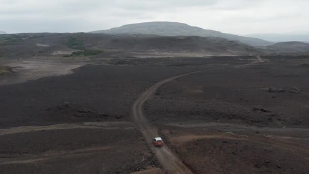 Incroyable vue aérienne du paysage volcanique stérile. Suivi avant du véhicule circulant sur un chemin de terre et un gué à lit de rivière sec. Islande — Video