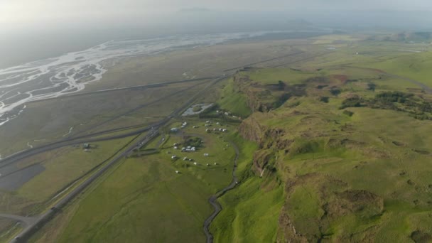 悬崖峭壁和高原平坦景观的空中全景.塞尔贾兰多斯瀑布附近宽阔的河流、道路和野营场地。冰岛 — 图库视频影像