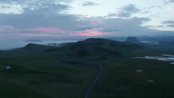 Menakjubkan pemandangan lanskap Nordik. Warna-warni langit di atas perbukitan hijau pedesaan saat matahari terbit atau terbenam. Jalan menuju padang rumput. Islandia — Stok Video