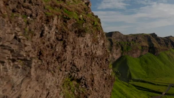 Flyga längs oländig bergvägg upplyst av låg sol. Avslöja fantastisk natur med höga Seljalandsfoss vattenfall. Strömmen av vatten faller från klippkanten. Island — Stockvideo