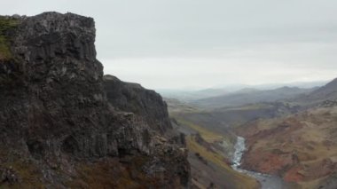 İleri, geniş ve derin kanyondan oluşan kayalık bir duvar boyunca uçar. Dağ manzarasında panoramik manzara. Haifoss, İzlanda