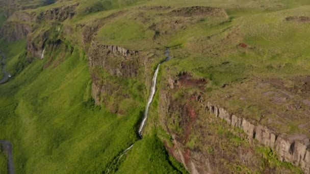 Images de glissades et de casseroles d'eau coulant sur une falaise rocheuse. Incroyable paysage naturel préservé autour de la cascade Seljalandsfoss. Islande — Video