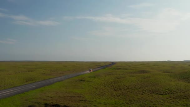 Пролетите над плоским ландшафтом. Внедорожник едет по дороге через северную сельскую местность на Golden Hour. Исландия — стоковое видео