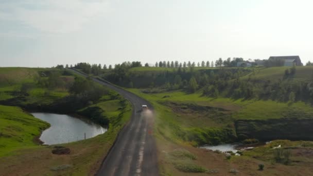 Sledovat auto na severské venkově. Auto jede po prašné cestě mezi travnatými pláněmi. Přesměrování vozidla. Island — Stock video