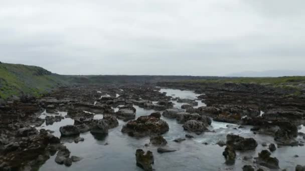 En avant voler au-dessus du ruisseau dans le paysage volcanique. Eau coulant entre des pierres accidentées dans le lit de la rivière. Aldeyjarfoss, Islande — Video