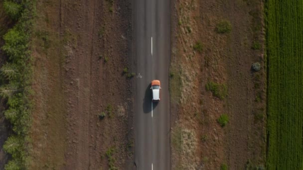 在农村，空中鸟儿的目光俯瞰着从十字路口开始在空旷的道路上行驶的车辆。冰岛 — 图库视频影像