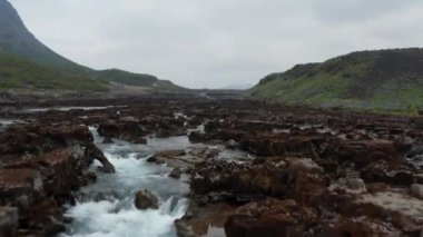 Pürüzlü nehir yatağının üzerinde alçak su seviyeli alçak uçuş. Keskin volkanik taşların arasından akan akarsu. Aldeyjarfoss, İzlanda