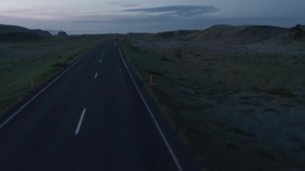 Voorwaartse tracking van auto rijden op de weg in de Scandinavische platteland. Panoramisch uitzicht op het landschap bij schemering. IJsland — Stockvideo