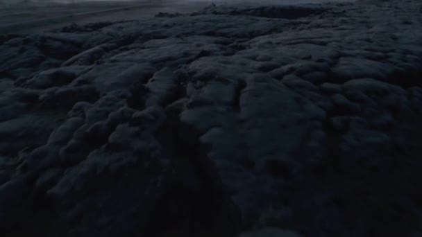 Высокоугольный вид структурированного вулканического грунта. Поднимаем вверх пейзажную панораму и людей, стоящих вокруг машины. Красочное сумеречное небо. Исландия — стоковое видео