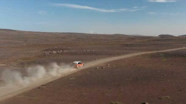Rastreamento de duas cores carro SUV dirigindo rápido na estrada empoeirada em paisagem vulcânica estéril. Dia ensolarado nas planícies nórdicas. Islândia — Vídeo de Stock
