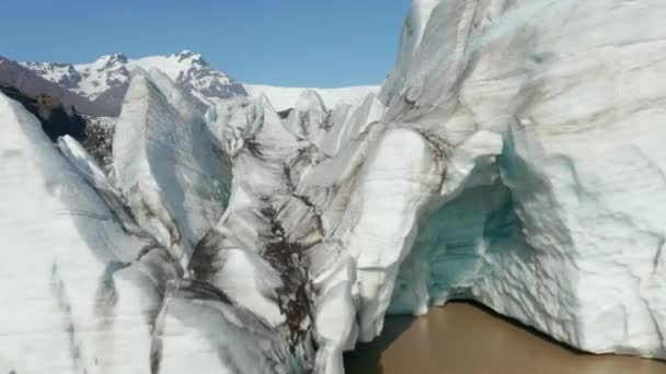 Felfedve a gleccser jégtömegét a völgyben. Jeges fehér jég hasadékokkal és hegygerinc a háttérben. Izland — Stock videók