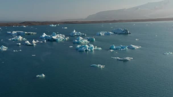 북극의 호수 표면에 떠다니는 빙하의 조각들 입니다. 태양에 의해 조명되는 풍경. 아이슬란드 — 비디오