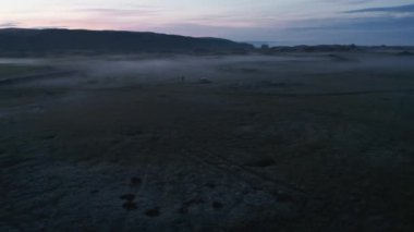 Düz düzlükteki off-road yolunda araba parkının kaydırağını ve yanını çek. Kuzeyin puslu panoramik manzarası. İzlanda