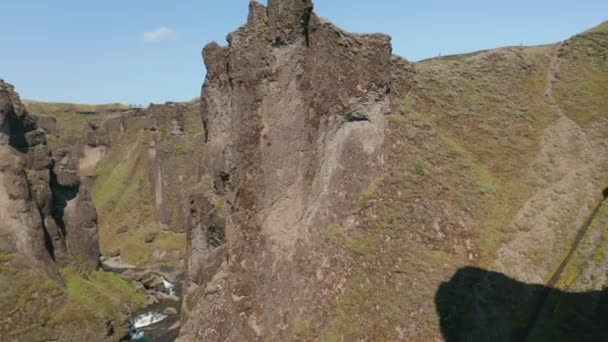 Puncak berbatu sempit tinggi di atas sungai di ngarai rusa. Hari yang cerah di alam Nordik yang diawetkan. Ngarai Fjadrargljufur, Islandia — Stok Video