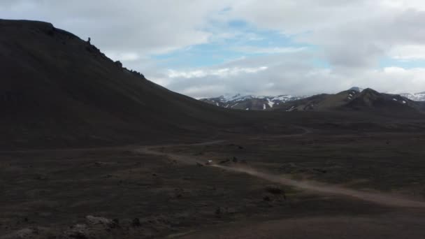 Snabb flytta SUV bil på grusväg på landsbygden. Barren vulkaniska landskap. Berg i bakgrunden. Island — Stockvideo