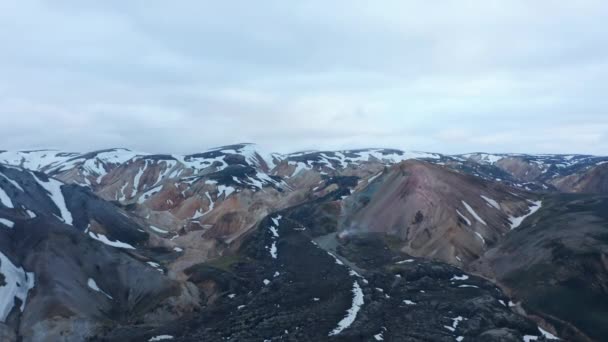 Imágenes descendentes panorámicas aéreas del paisaje montañoso. Cordilleras cubiertas de nieve. Valle de Thorsmork, Islandia — Vídeo de stock