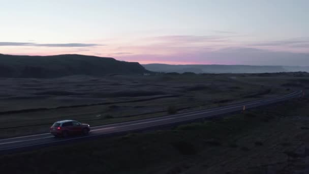 북유럽 풍경의 도로 여행. 저녁 시골 도로에서 차를 운전하는 것을 추적하고 있습니다. 화려 한 하늘. 아이슬란드 — 비디오